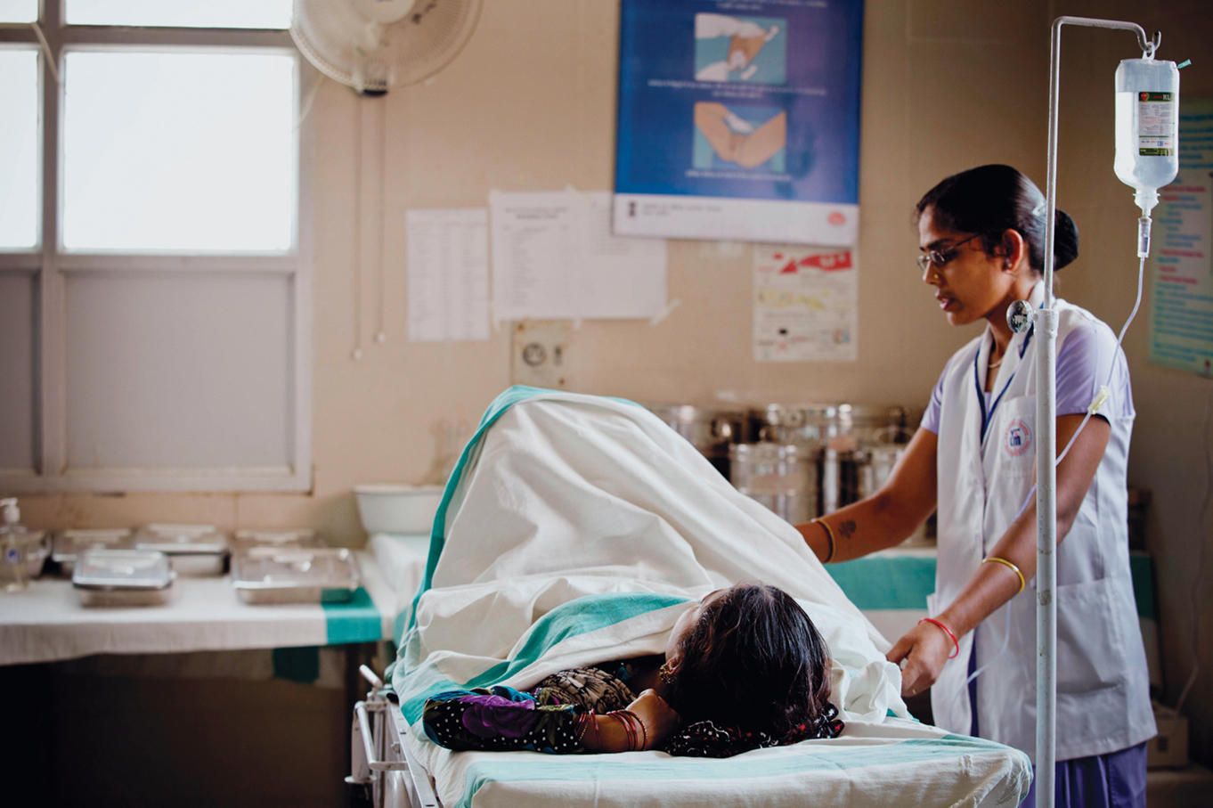 A trainee nurse who attends the nursing college that receives technical support from MCHIP talks to a patient who is about to deliver a baby in Allahabad, India Thursday, May 29, 2014. (Kate Holt/ MCHIP Photo/)